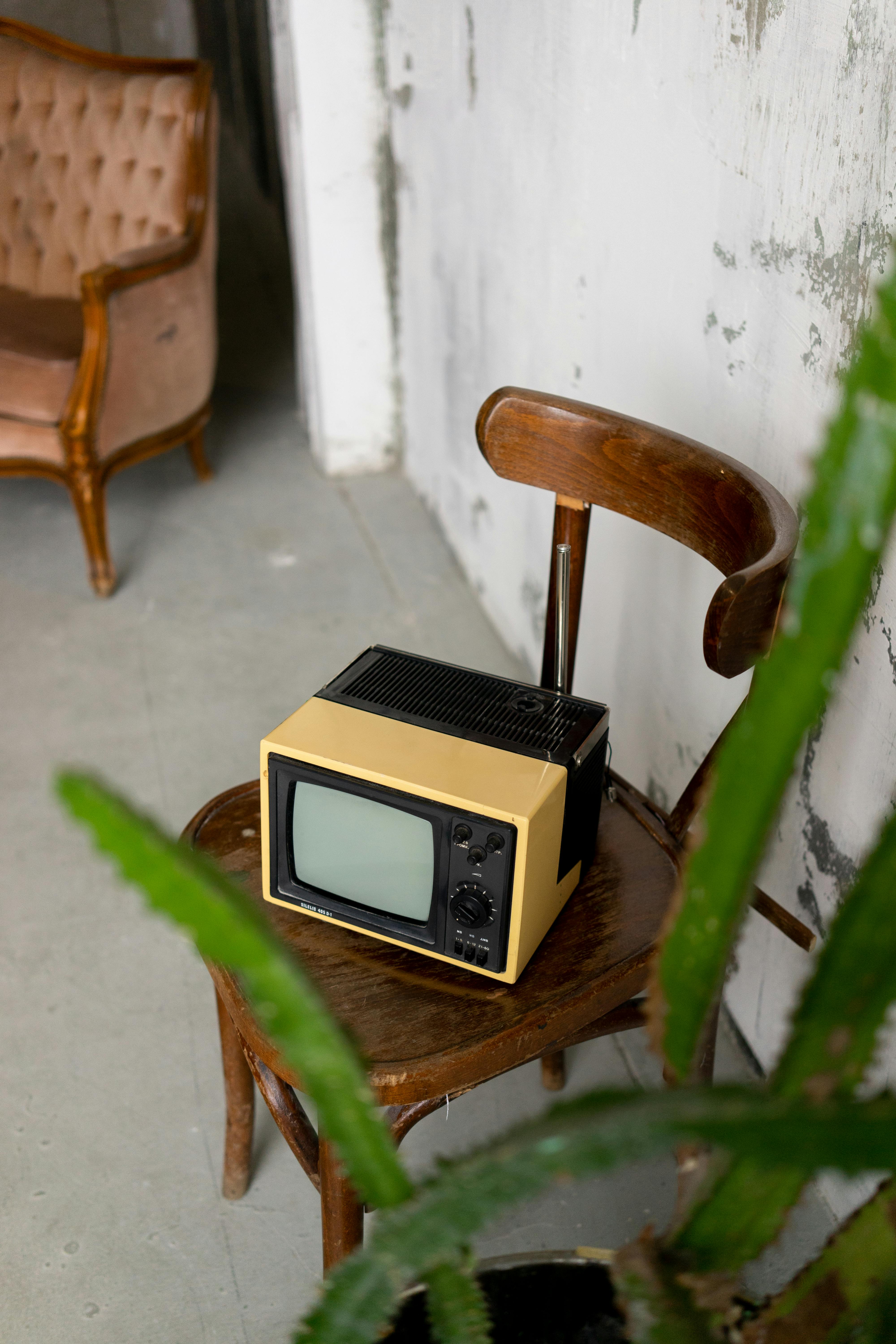 retro tv placed on chair in room with vintage furniture