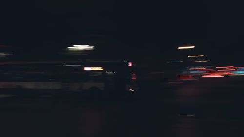 Free Defocused glowing lights of city road traffic with bus driving on road in darkness Stock Photo