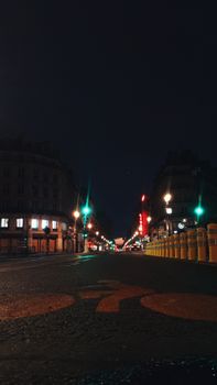 Ground level of paved road with bicyclist sign on pavement against glowing city buildings at night