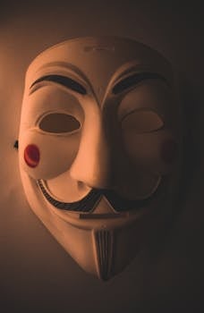 Close-up of a Guy Fawkes mask in moody lighting, symbolizing anonymity and intrigue.
