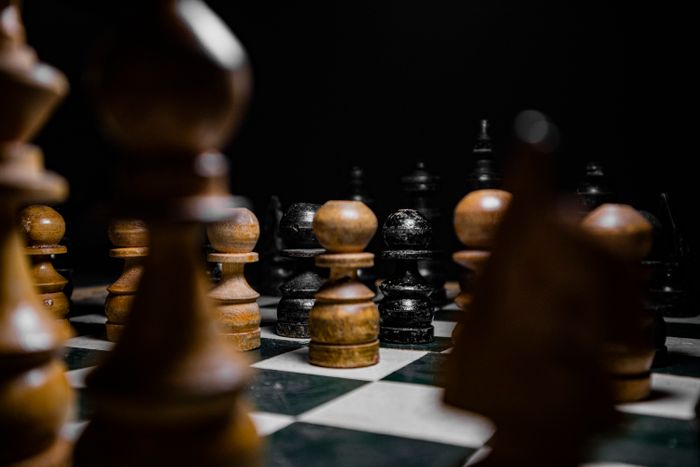Wooden chess pieces arranged on a board, evoking strategic gameplay