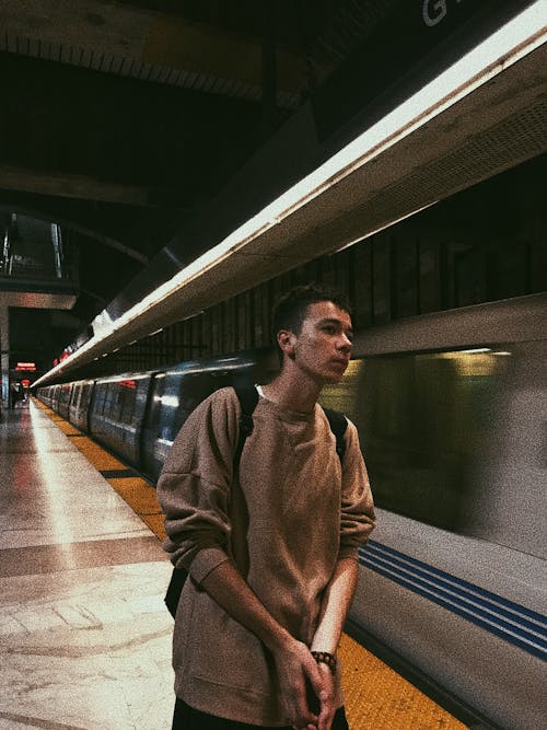 Young man waiting for train on platform