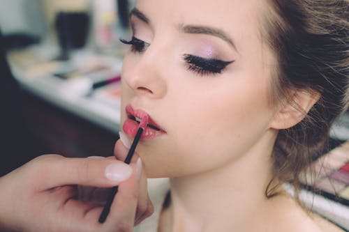 Free Woman Putting on Lipstick Stock Photo
