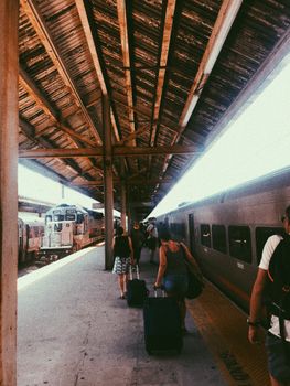 Diverse arrivals on train platform in casual clothes carrying bags and backpacks out of train and going to city