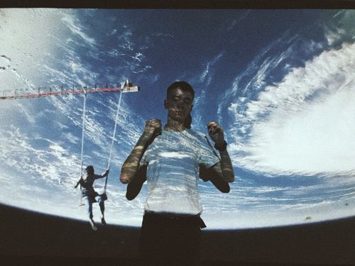 Free Young male with eyes closed standing with projection of Earth on body during movie scene and dreaming of traveling into space Stock Photo