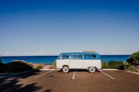 充满活力的蓝色万里无云的天空在老式拖车停在沥青旁边的海岸蓝色无尽的海洋在阳光下