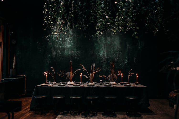 Row Of Stools Next To Long Table Covered With Tablecloth In Dark Hall