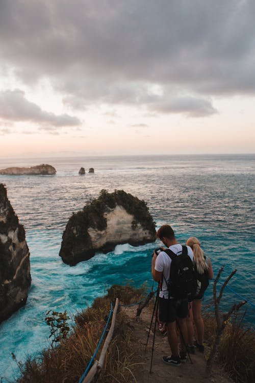 Faceless tourists taking photo of ocean