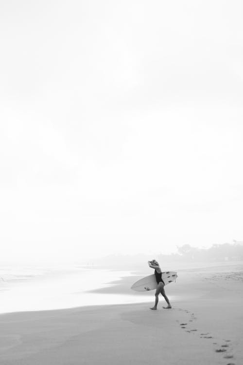 Woman in swimsuit walking on sandy beach