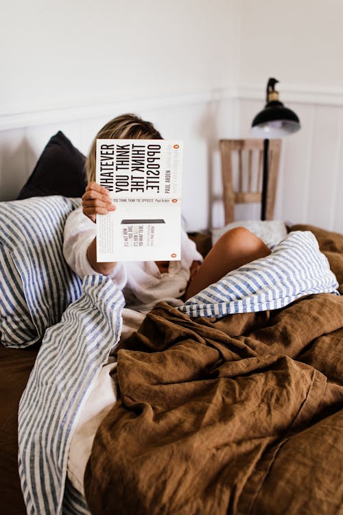 Anonymous woman with novel in bed