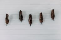 明亮的白色墙壁上展示着一双简约的复古木鞋