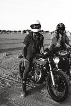 两个戴着头盔的人在广阔的沙漠里骑自行车，体现了自由和刺激