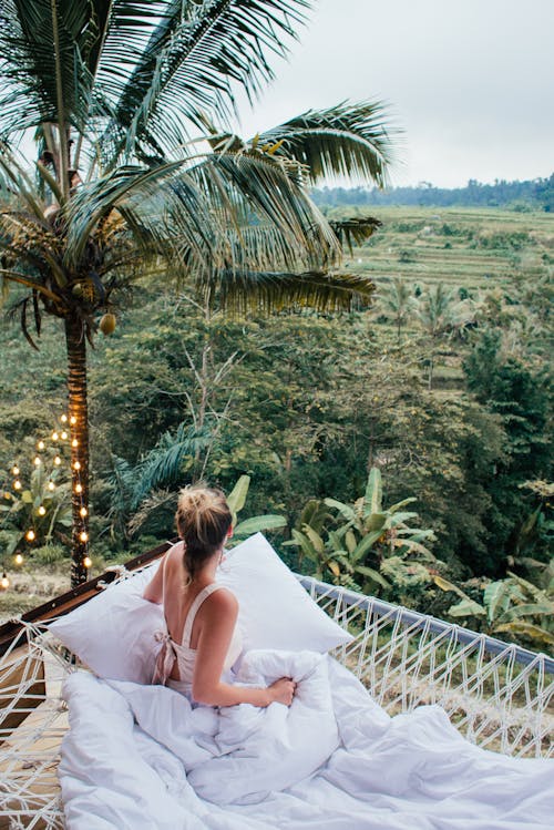 Faceless woman resting on hammock in exotic country