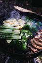 Vegetables and sausages on grill in daytime