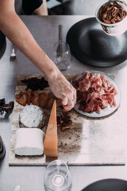 Faceless person serving dinner table in daytime