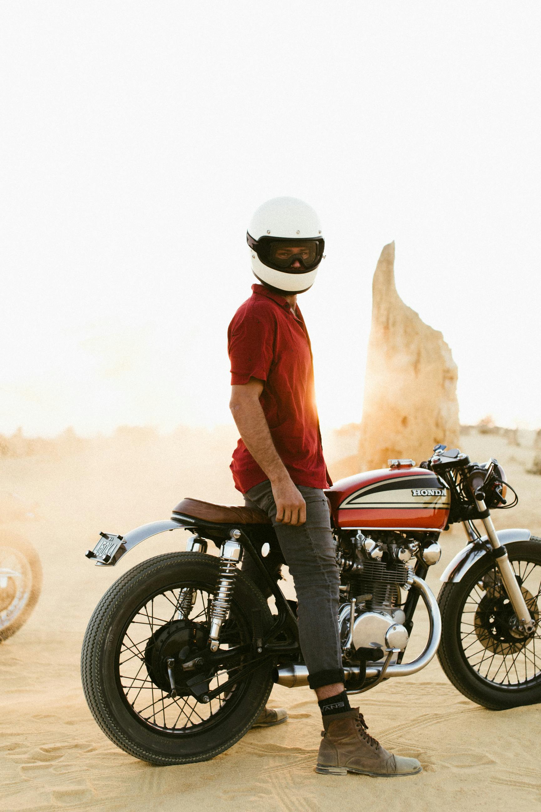 faceless motorcyclist in desert at sunset