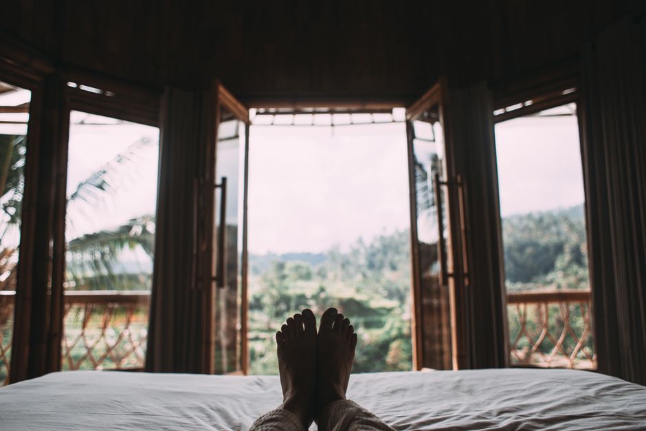 Person resting on a bed in a quiet room — the 2–3 day recovery period after ibogaine ceremony involves fatigue, ataxia, and disrupted sleep as the body and nervous system reset