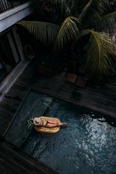 从花车上俯视的女人，正享受着宁静的热带池畔环境