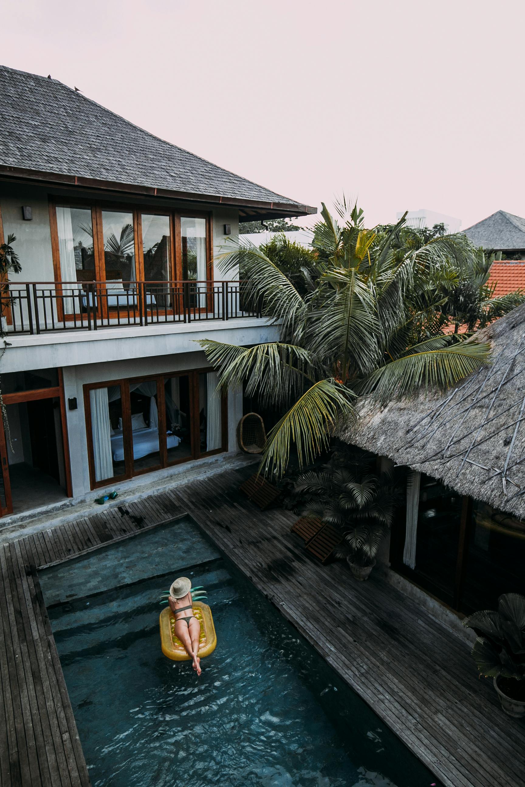 woman resting in pool near cottage