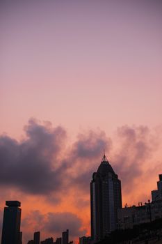 五颜六色的日落天空下，摩天大楼映衬着充满活力的城市景观