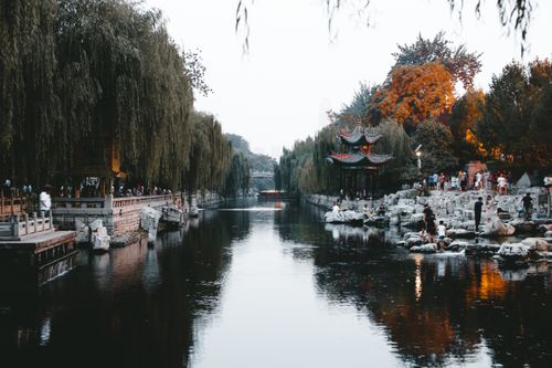 Free City channel between park with lush trees on embankment and local structure on public shore Stock Photo