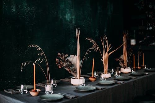 Free Creative design of festive table with dry plants in vases and tableware in cozy restaurant Stock Photo