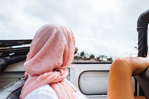 Free Unrecognizable female in shawl and sunglasses relaxing in convertible automobile during journey in nature Stock Photo