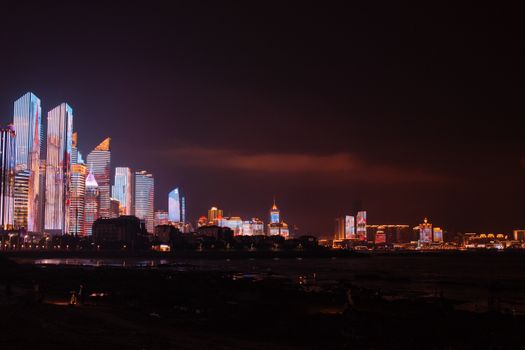 夜晚，灯光照亮的摩天大楼倒映在水面上，展现出令人惊叹的城市景观与活力