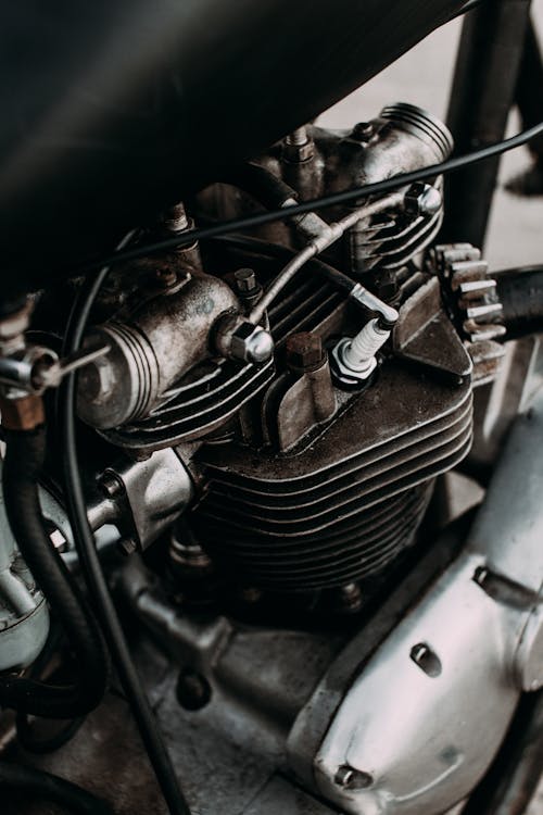 Part of motorbike with engine and metal details on asphalt road of city