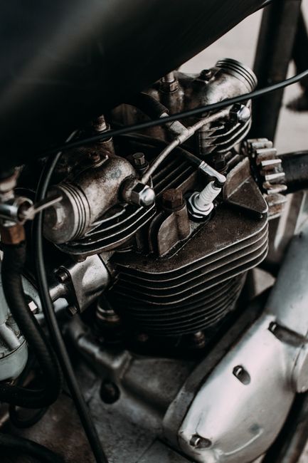 Part of motorbike with engine and metal details on asphalt road of city