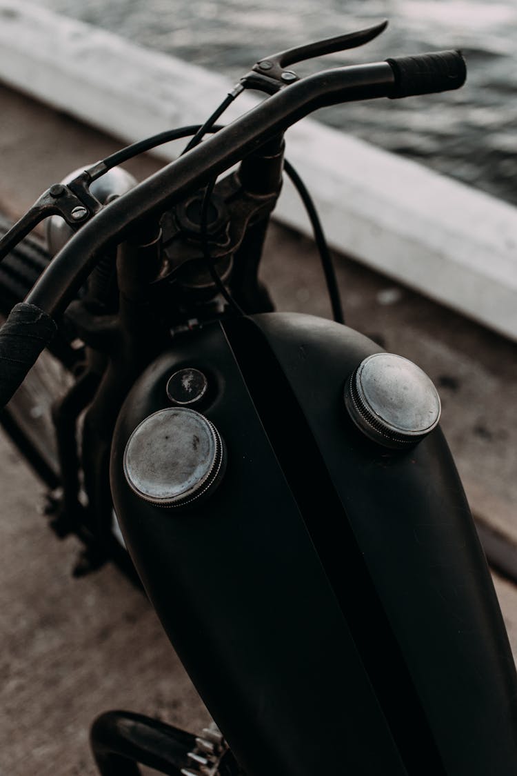 Black Motorbike On Embankment Near River In Daytime