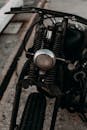 一辆老式摩托车的特写，展示了前灯和悬架