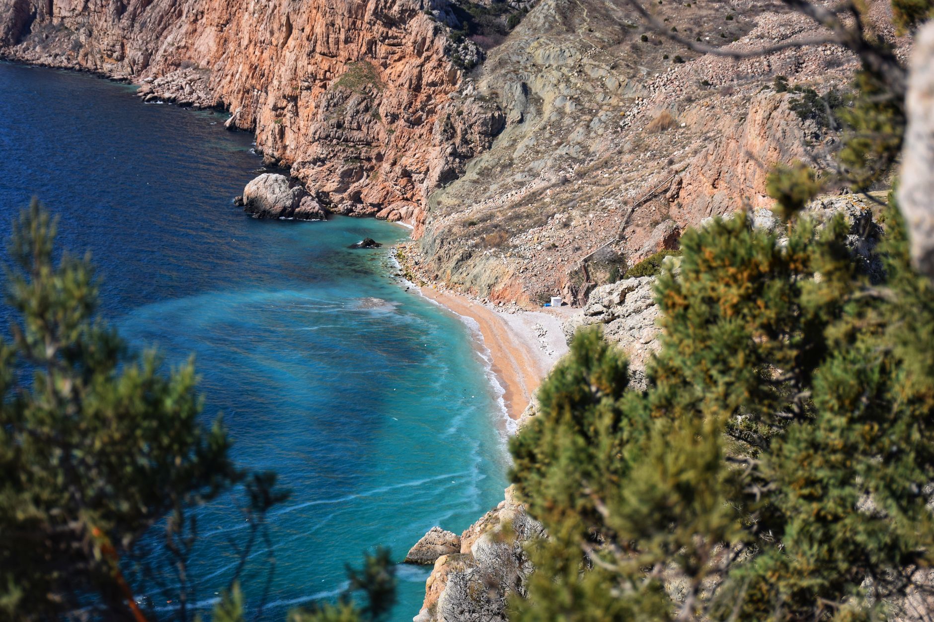 Stunning aerial view of a sandy beach with turquoise waters surrounded by cliffs in Sevastopol, Crimea.