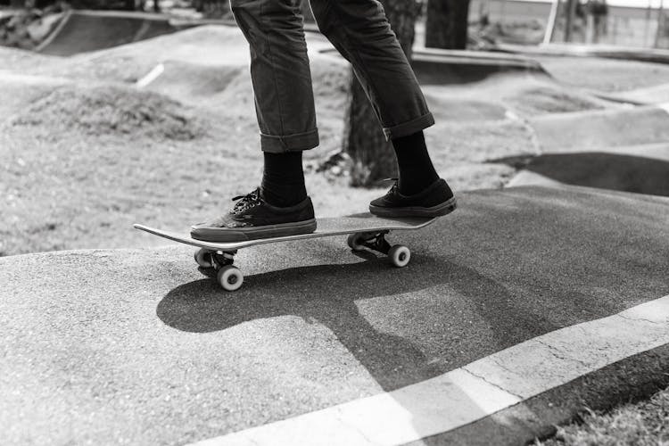 Crop Athlete Skateboarding On Wavy Road In Town