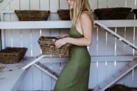 Crop woman with basket in wooden coop