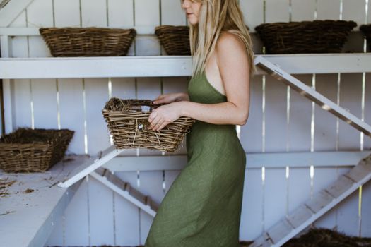 Crop woman with basket in wooden coop