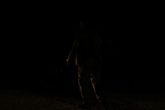 夜间，一个匿名的作物剪影举起手臂站立