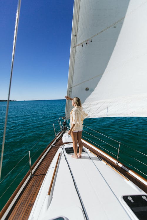 Unrecognizable traveler contemplating sea from yacht during summer trip