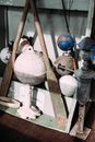 Assorted aged buoys with rough surface near pair of oars on wooden floor in shed