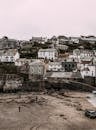 Small village with shabby houses located on hill near flooded terrain with high water level against cloudless sky in countryside