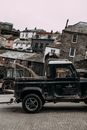 Old car riding on pavement near aged houses