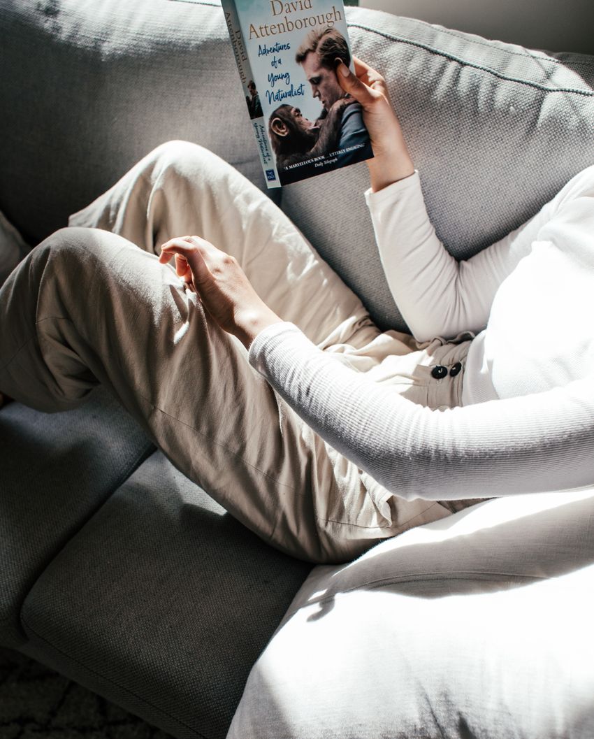 Mujer leyendo un libro en el sofá