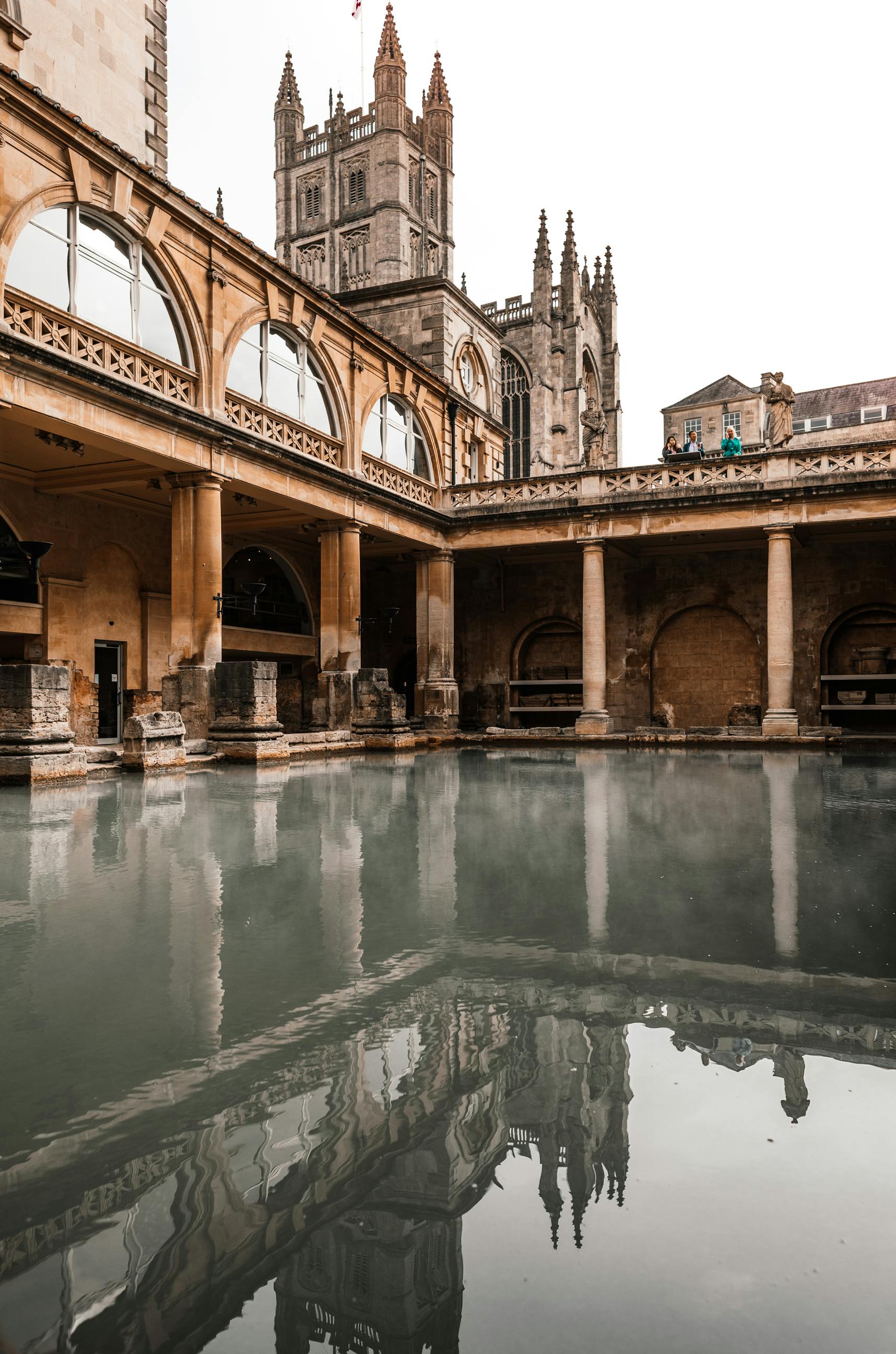 old temple facade reflecting in roman baths in england
