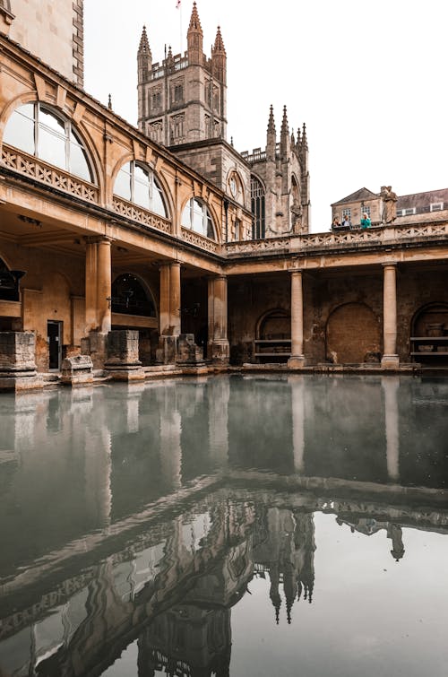 Old temple facade reflecting in Roman Baths in England