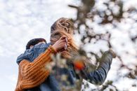 一对夫妇穿着休闲毛衣在户外拥抱，传递着温暖与亲情