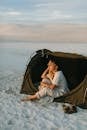 Dreamy tourist in tent contemplating desert during summer trip