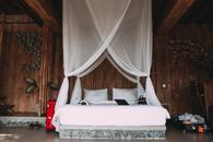 Cozy hotel bed with laptop under canopy