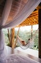 Unrecognizable traveler in hammock against bed in tropical resort