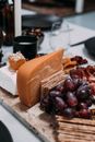 High angle of delicious appetizers with delicious cheese and sweet berry on marble cutting board