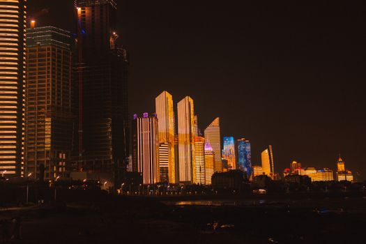 令人惊叹的城市天际线中，摩天大楼的照明与城市灯光点亮了黑暗的夜空